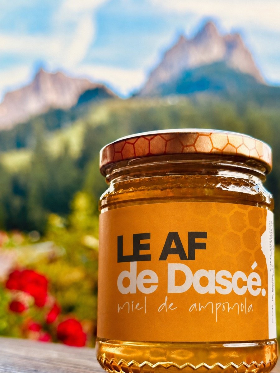 Vasetto di miel de ampomola da 500 g davanti al Sas da le Doudesc